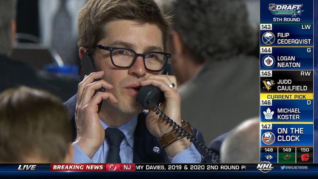 Maple Leafs GM Dubas works two phones simultaneously at the NHL Draft