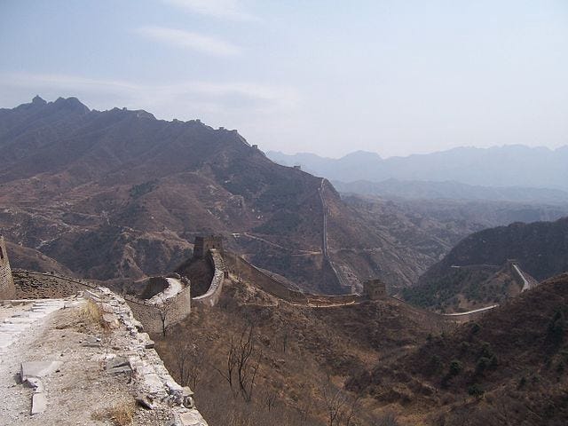 The Great Wall of China on a dry looking day with brown grass covering the mountains