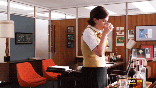 Peggy Olson virando um copo de uísque no escritório