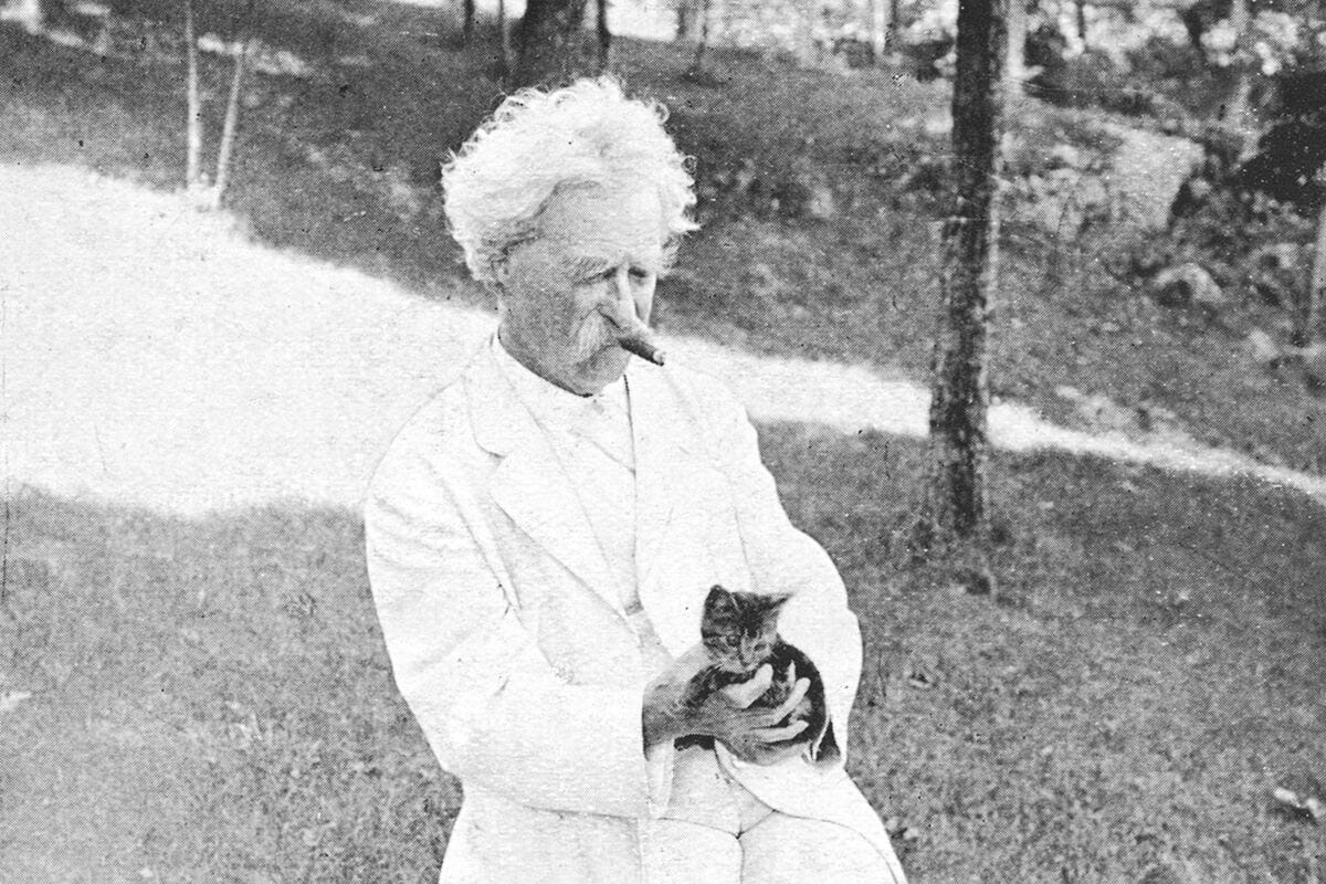 Mark Twain holding a cat.