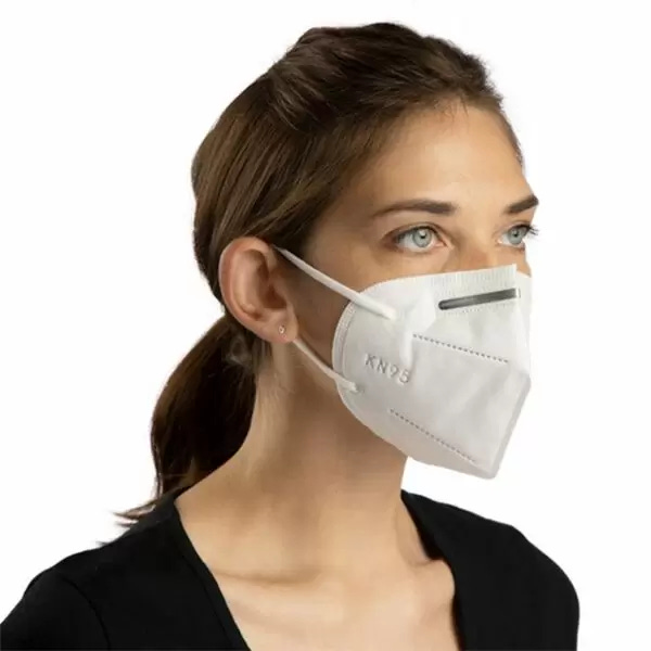 Woman wearing a KN95 mask, staring off into the distance, wondering when this will all end.