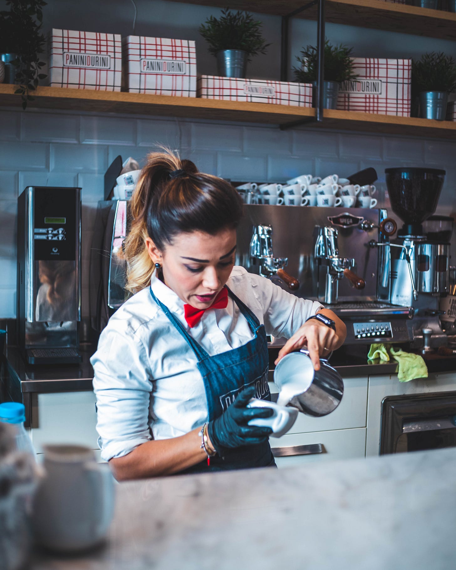 woman barista pouring milk into latte