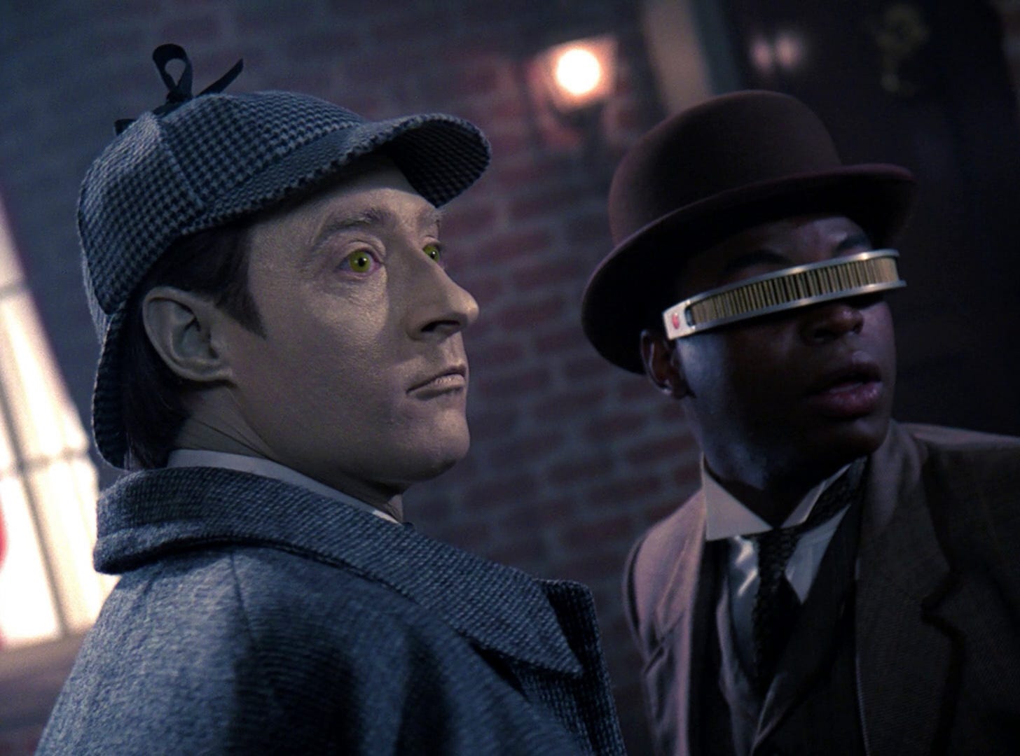 This image shows Lieutenant Commander Data (played by Brent Spiner) and Lieutenant Commander Geordi La Forge (played by LeVar Burton) dressed respectively as Sherlock Holmes and Dr. John Watson. Both men stand in a holodeck re-creation of a Victorian London street and look off-camera at something that alarms them. This image shows Lieutenant Commander Data (played by Brent Spiner) and Lieutenant Commander Geordi La Forge (played by LeVar Burton) dressed respectively as Sherlock Holmes and Dr. John Watson. Both men stand in a holodeck re-creation of a Victorian London street and look off-camera at something that alarms them.
