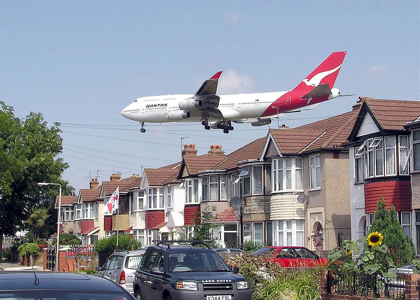 A Quantas Boeing 747 landing at Heathrow Airport, passing over houses