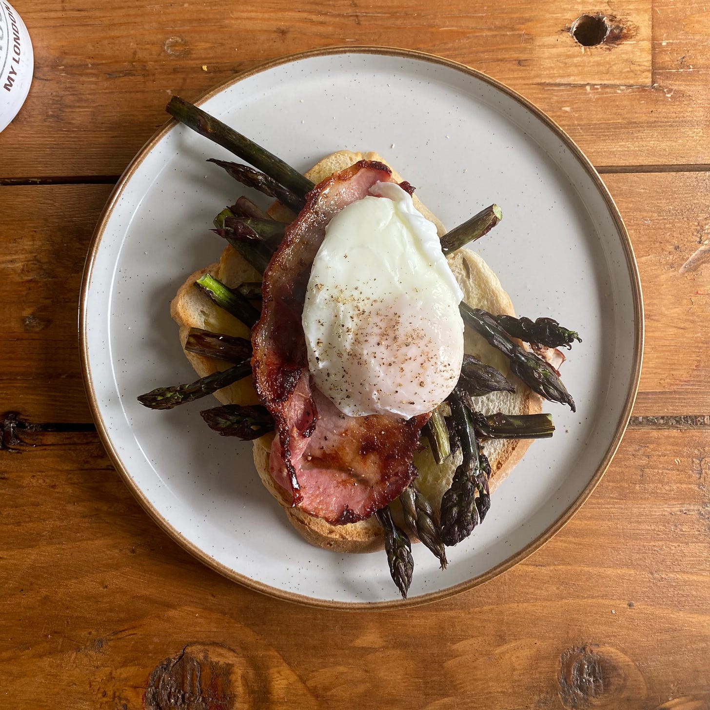 Plate with toast, bacon, asparagus and a poached egg