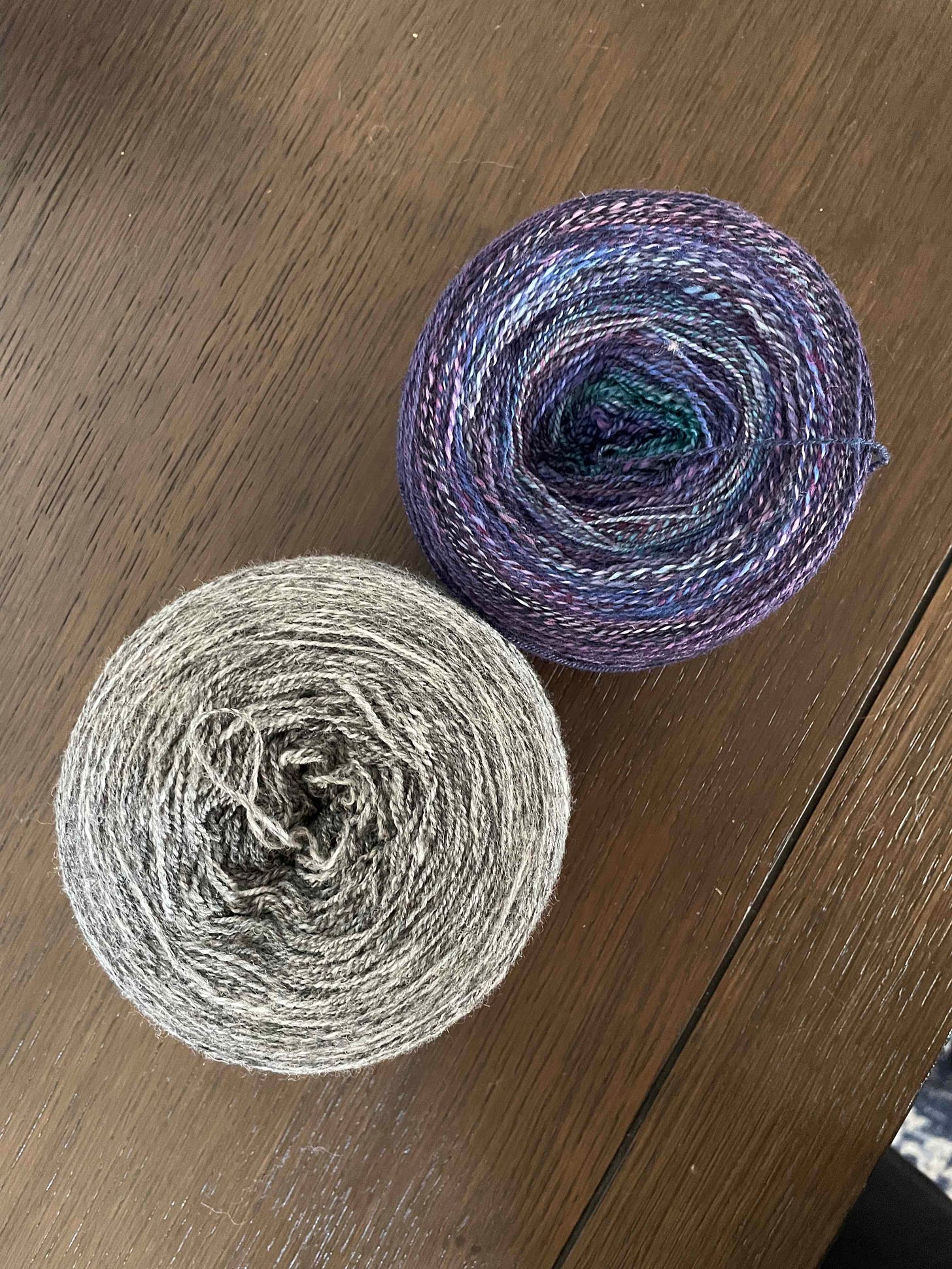 Two balls of yarn, one gray and one purple