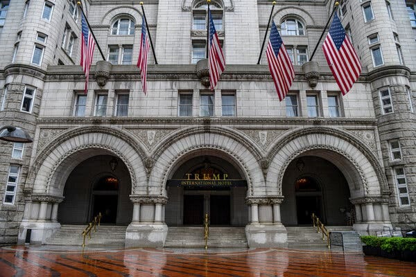 United States flags hang above the entrance to the Trump International Hotel.
