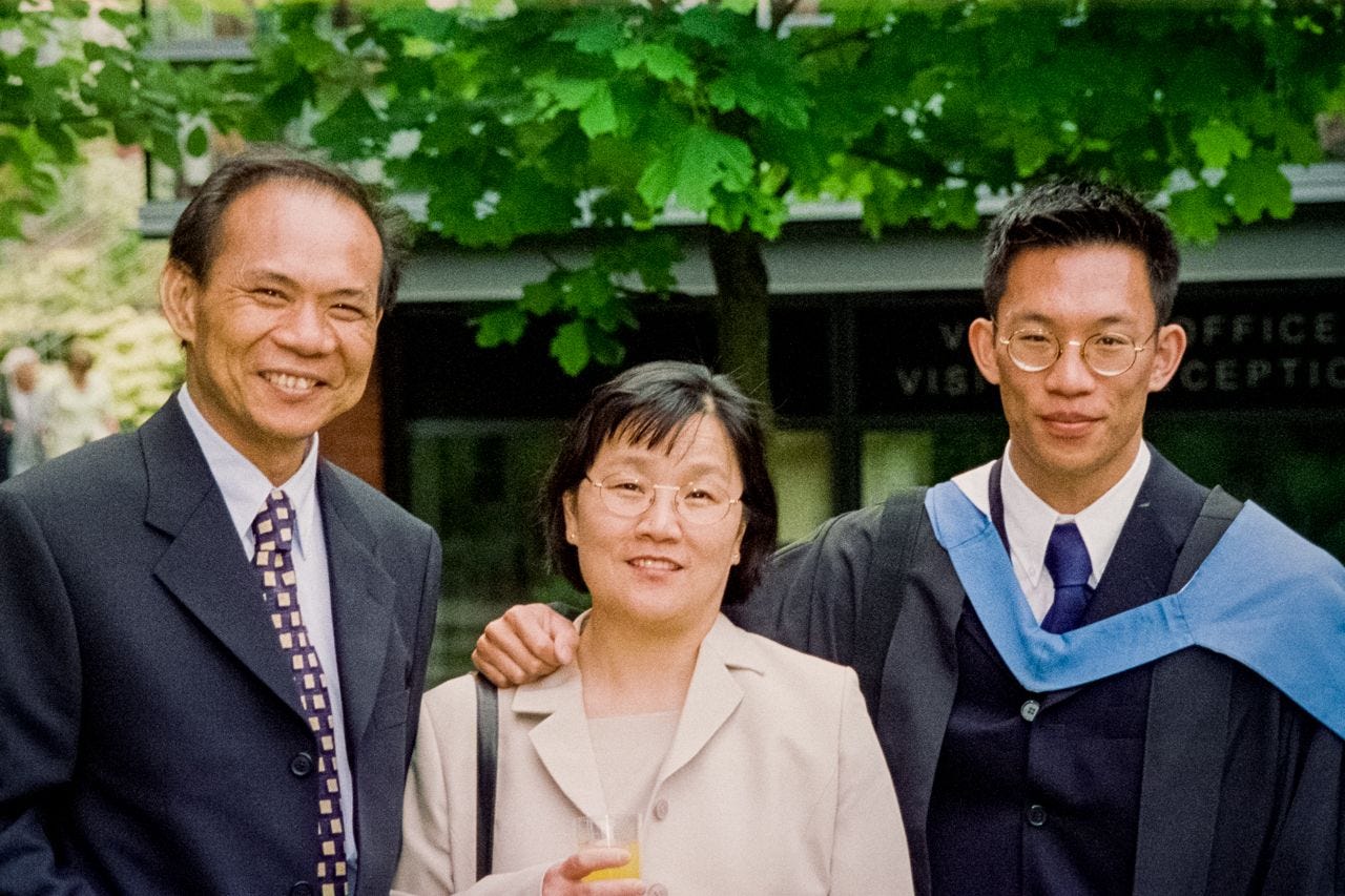 Myself, in a graduation gown, with my parents.