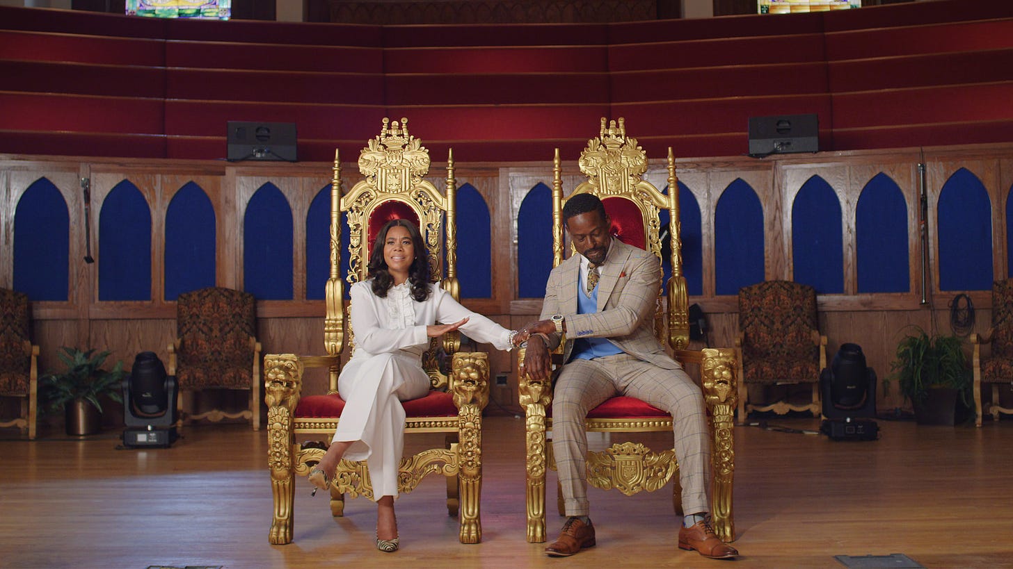 Regina Hall and Sterling K. Brown sitting as their characters in a still from Honk for Jesus