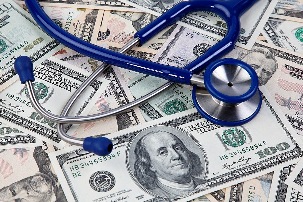A doctor's stethoscope on top of a pile of money.