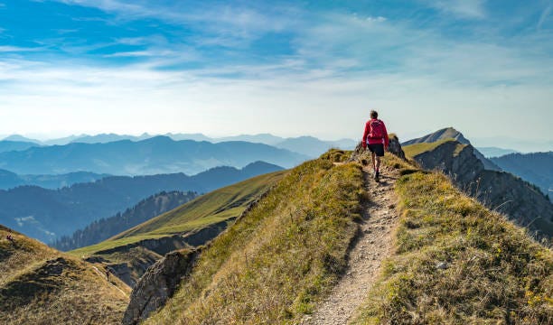 Hiking in the Allgaeu Alps nice senior woman, hiking in fall, autumn  on the ridge of the Nagelfluh chain near Oberstaufen, Allgaeu Area, Bavaria, Germany, Hochgrats summit in the background beautiful path stock pictures, royalty-free photos & images