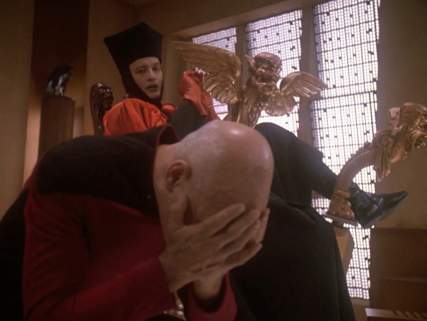 This image from Star Trek: The Next Generation's series finale ("All Good Things. . .") shows Q (played by John de Lancie), dressed as a 21st-Century judge, giving reassurance to Captain Jean-Luc Picard (played by Patrick Stewart). Picard holds his head in his hands. This image from Star Trek: The Next Generation's series finale ("All Good Things. . .") shows Q (played by John de Lancie), dressed as a 21st-Century judge, giving reassurance to Captain Jean-Luc Picard (played by Patrick Stewart). Picard holds his head in his hands.