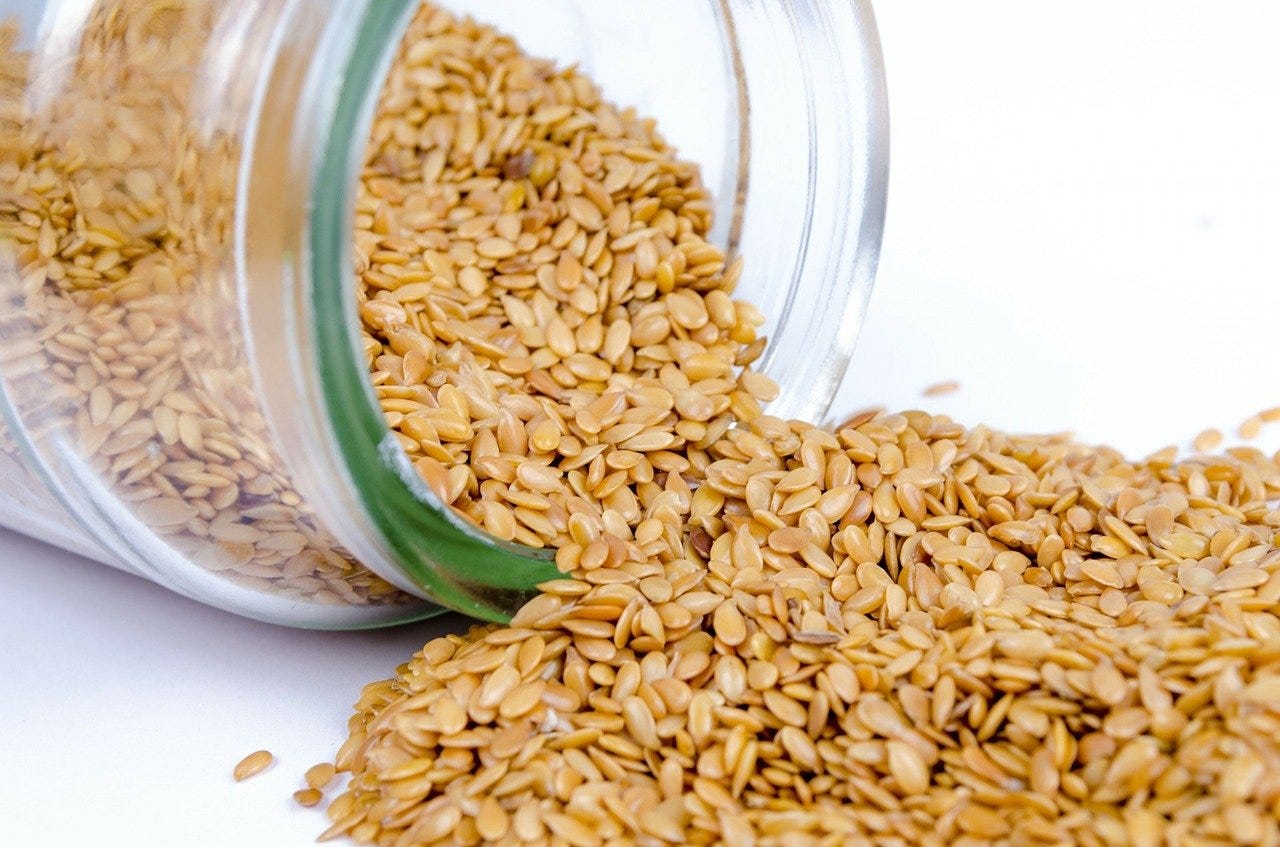 Sesame seeds fall out of a glass jar lying on its side. Sesame seeds are an allergen for 1.5 million Americans
