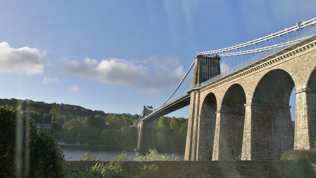 A picture of the Menai Strait Suspension Bridge in Wales, linking Wales to Angelsey. It is a sunny day