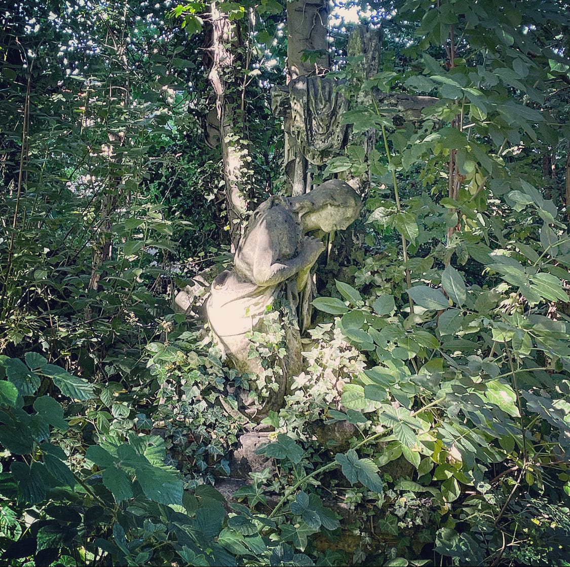 Colour photo of a stone angel memorial at a grave in Abney Park Cemetery