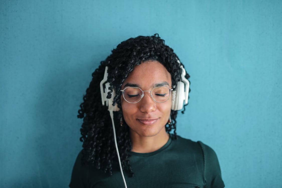 Free Portrait Photo of Smiling Woman in Black Top and Glasses Wearing White Headphones Stock Photo