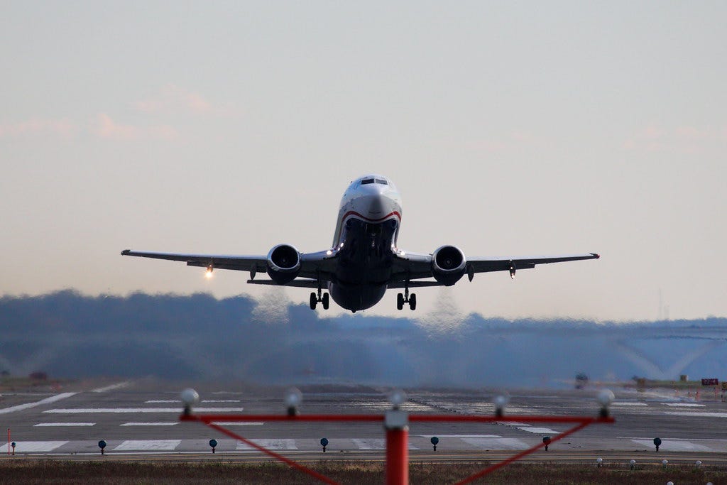 Photo of a US Airways Boeing 737 taking off, as seen from beyond the end of the runway.