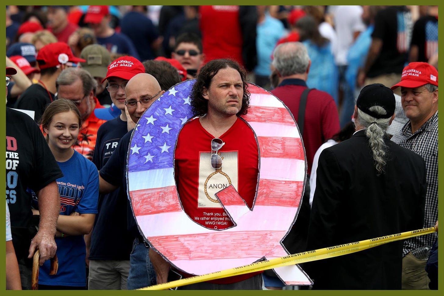 David Reinert holds a large "Q" sign while waiting in line on to see President Trump at his rally in Wilkes Barre, Pennsylvania, in 2018. The number of Americans who believe the main tenets of the conspiracy theory has risen by 4 per cent over the past year