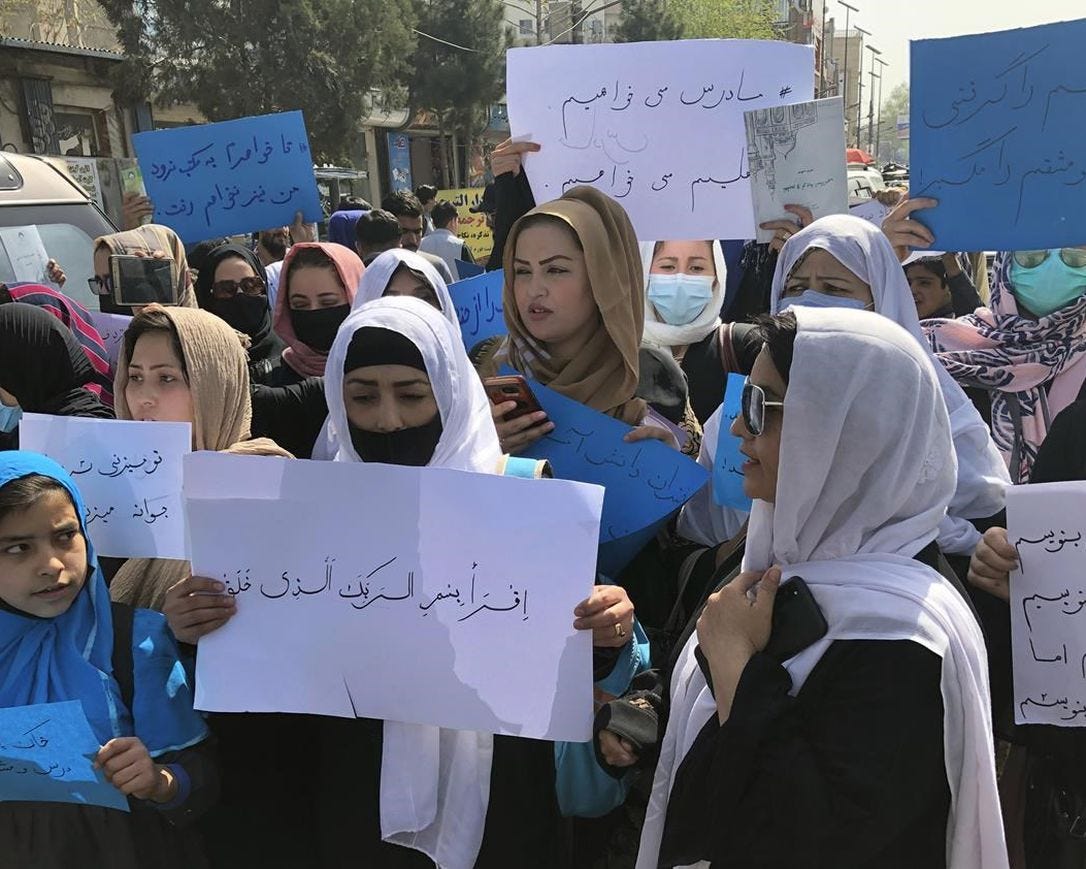 Afghan women chant and hold signs of protest during a demonstration in Kabul, Afghanistan, Saturday, March 26, 2022. Afghanistan's Taliban rulers refused to allow dozens of women to board several flights, including some overseas, because they were traveling without a male guardian, two Afghan airline officials said Saturday.