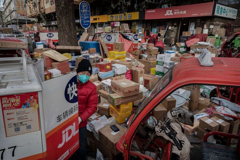 PHOTO: A delivery driver organizes packages in the street that are part of a backlog due to COVID-19 outbreaks outside a depot on Dec. 21, 2022 in Beijing, China.