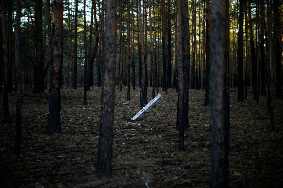 Part of a Russian rocket sticks out of the ground in a forest.