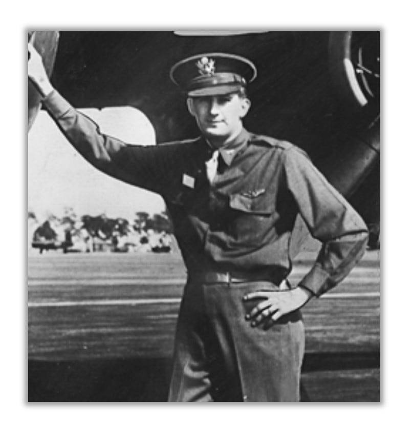 Elmer Gedeon, in uniform, leaning against a plane.