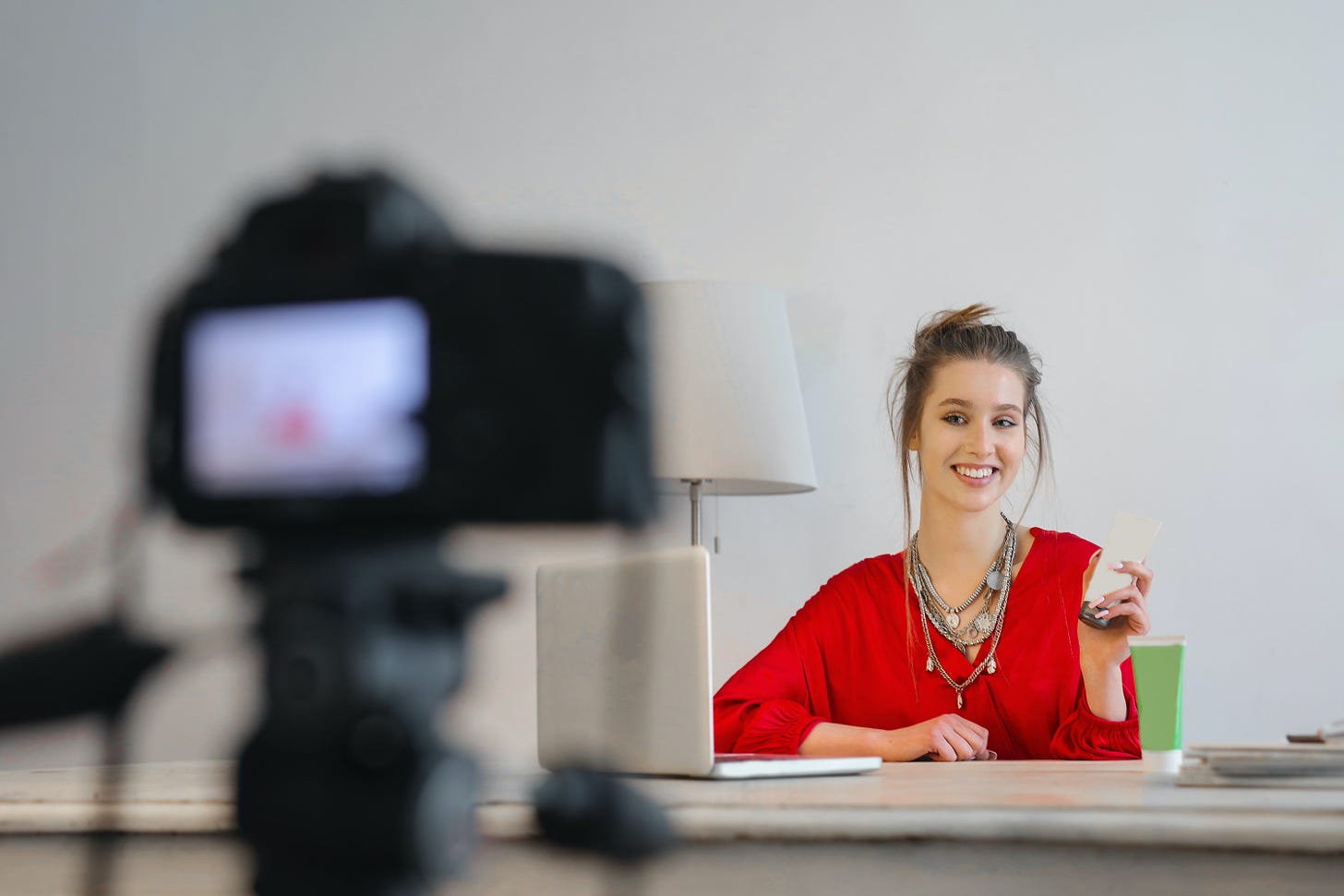 Woman in Red Shirt Sitting by the Table