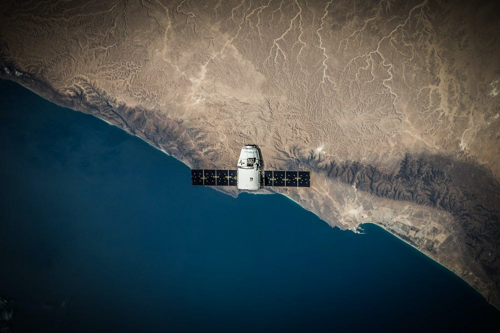 A space satellite hovering above the coastline