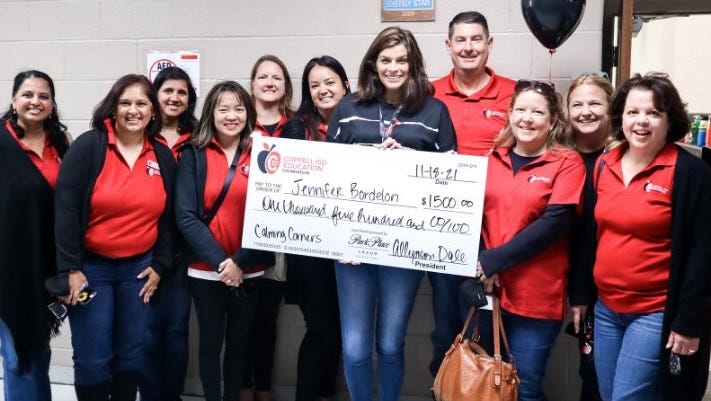 Coppell ISD Education Foundation volunteers present a giant check to Denton Creek Elementary School counselor Jennifer Bordelon