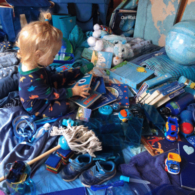 Animated loop of a baby playing in a pile of blue stuff.