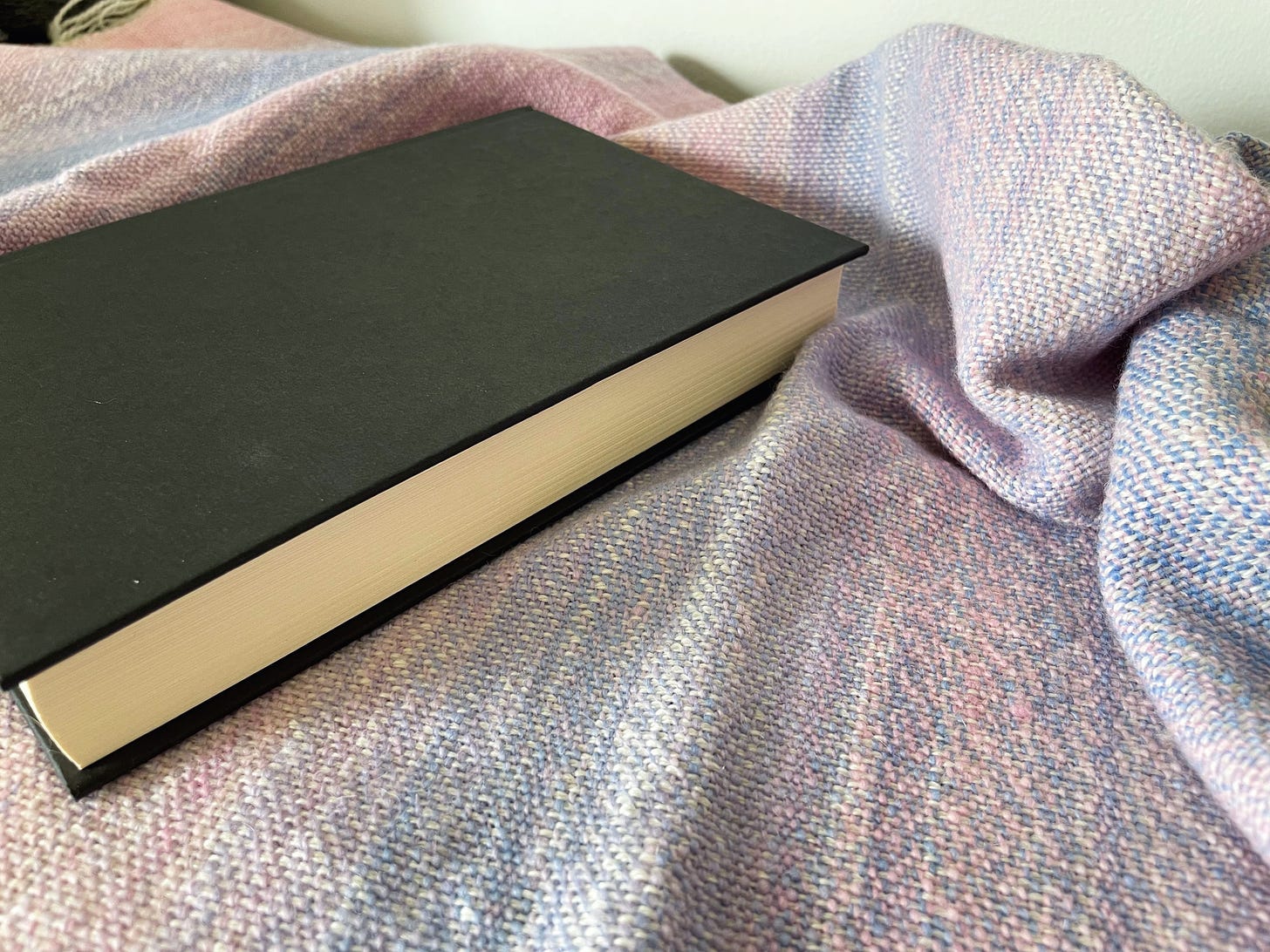 A book on a pastel woven cloth