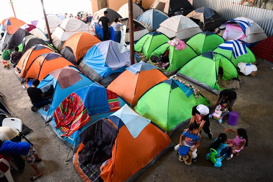 Children play as families live in tents the Movimiento Juventud 2000 shelter with refugee migrants from Central and South American countries including Honduras and Haiti seeking asylum in the United States, as Title 42 and Remain In Mexico border restrictions continue, in Tijuana, Baja California state, Mexico on April 9, 2022.