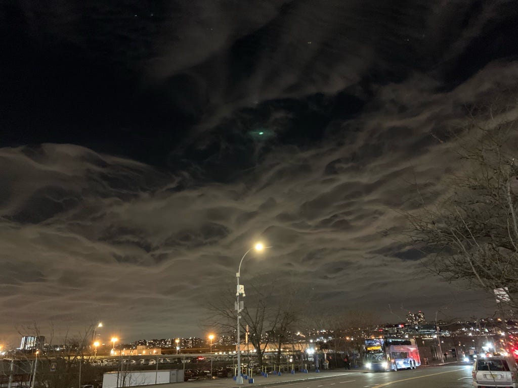 Image shows a sky filled with a cover of thin clouds that have a continuous roil to them, giving the effect of almost a sheet of crepe paper in the sky.