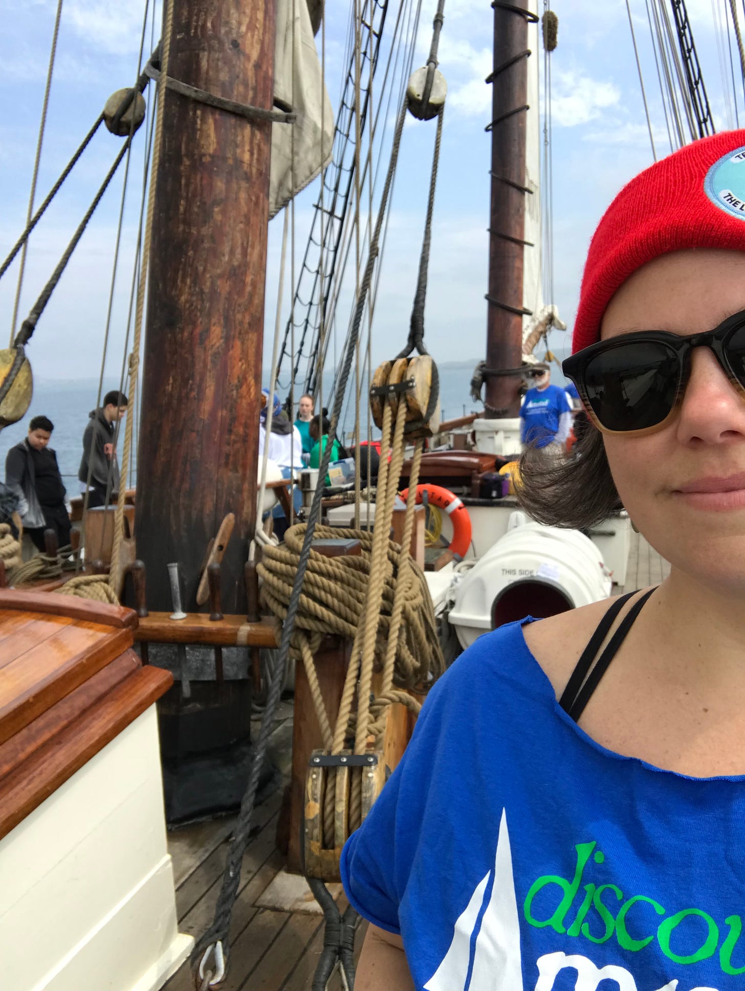 Anne Bryant crewing aboard AMISTAD, a Baltimore clipper built for educational purposes. Students in the background are attending educational programming stations about African culture and the special place AMISTAD has in American history while the boat is under way.