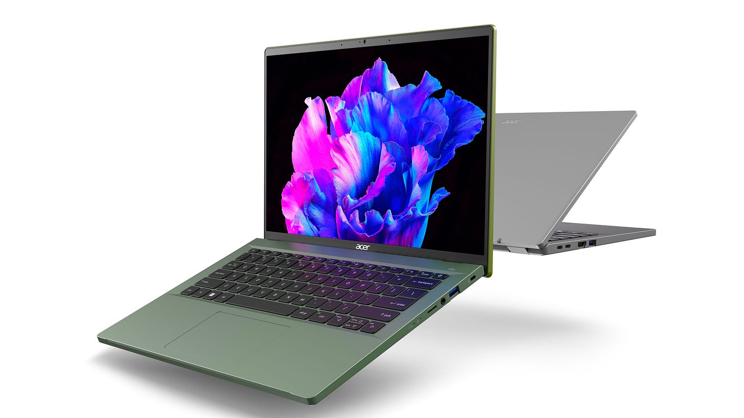 An Acer Swift Go 14 in green faces the camera while another one in silver, behind it, faces away