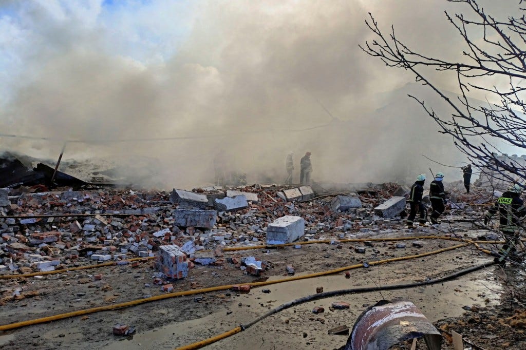 Rescuers work at a site of a warehouse storing products burned after shelling,