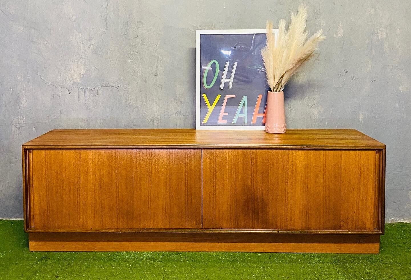 A beautiful G Plan sideboard on what looks like fake grass.