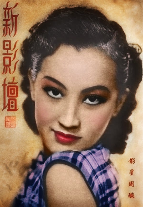 Colorized publicity portrait of Zhou Xuan. She is wearing a purple plaid sleeveless dress, smoky eye makeup, and bright red lipstick. Her hair is permed in loose waves and pulled back from her forehead. Colorized publicity portrait of Zhou Xuan. She is wearing a purple plaid sleeveless dress, smoky eye makeup, and bright red lipstick. Her hair is permed in loose waves and pulled back from her forehead.