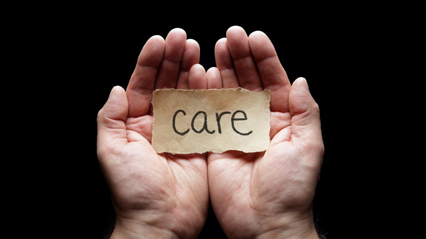 Image of two hands holding a paper that reads "care"