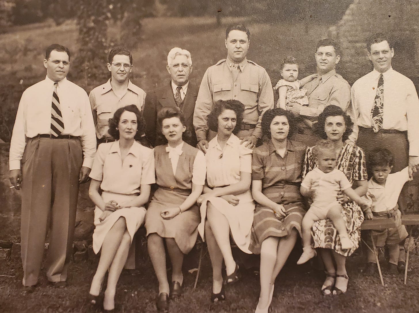A family portrait with the men standing in the back and the women seated in front of them.