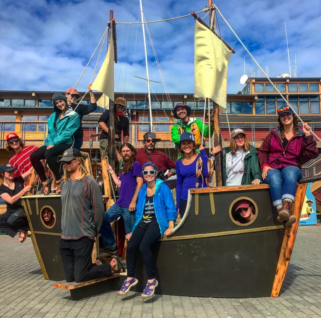 A group of people smile on a fake pirate ship.