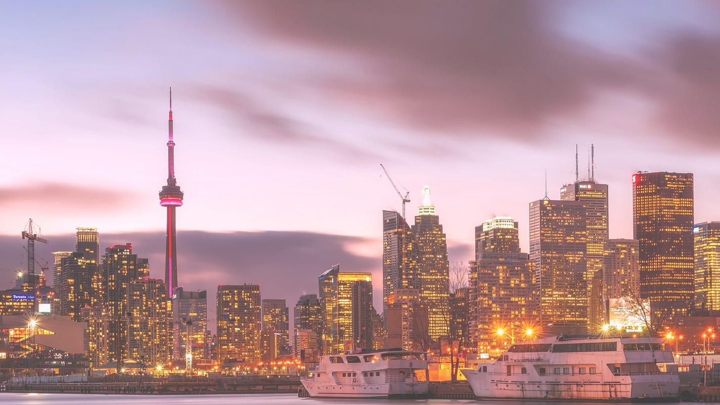 well-lit city buildings and ships at sunset