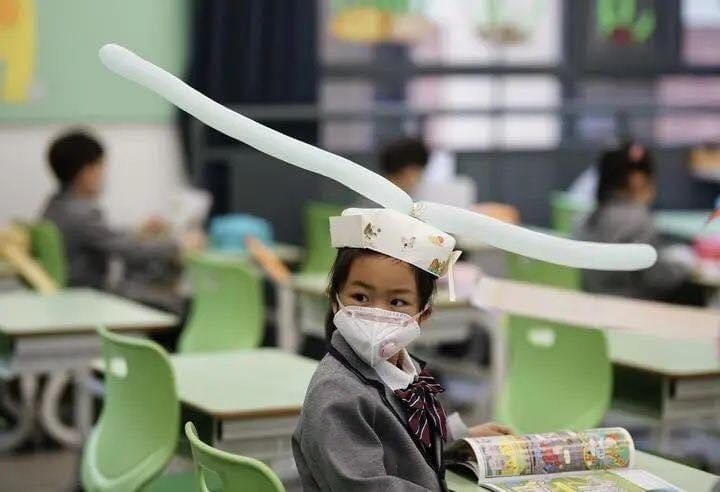 Students wear social distancing headgears as schools ...