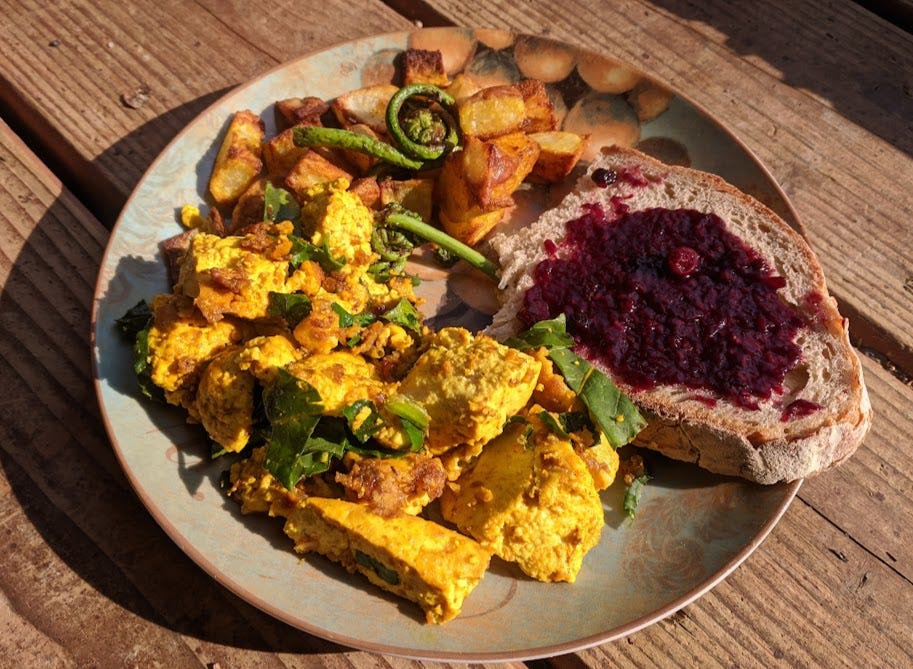 a plate of tofu migas with beet greens, roasted potatoes w/ fiddleheads and sourdough toast with last summer's berry jam a plate of tofu migas with beet greens, roasted potatoes w/ fiddleheads and sourdough toast with last summer's berry jam