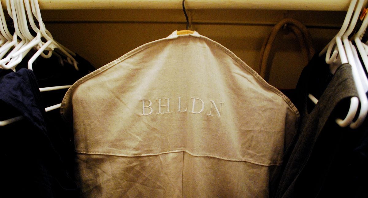 Tan dress cover hanger on a rack saying "BHLDN"