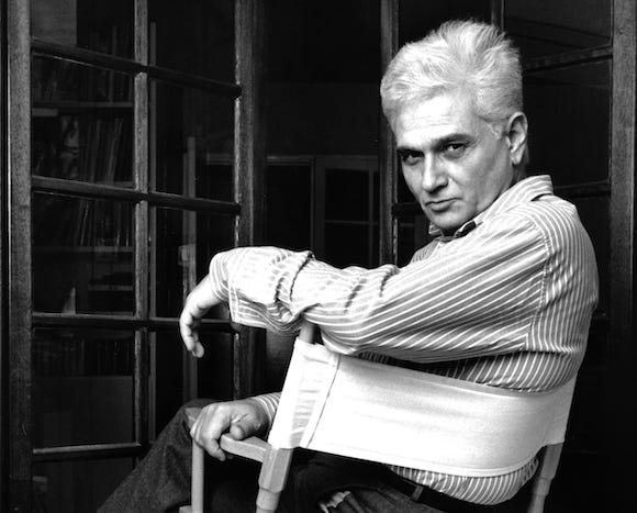 A black and white photo of Derrida.