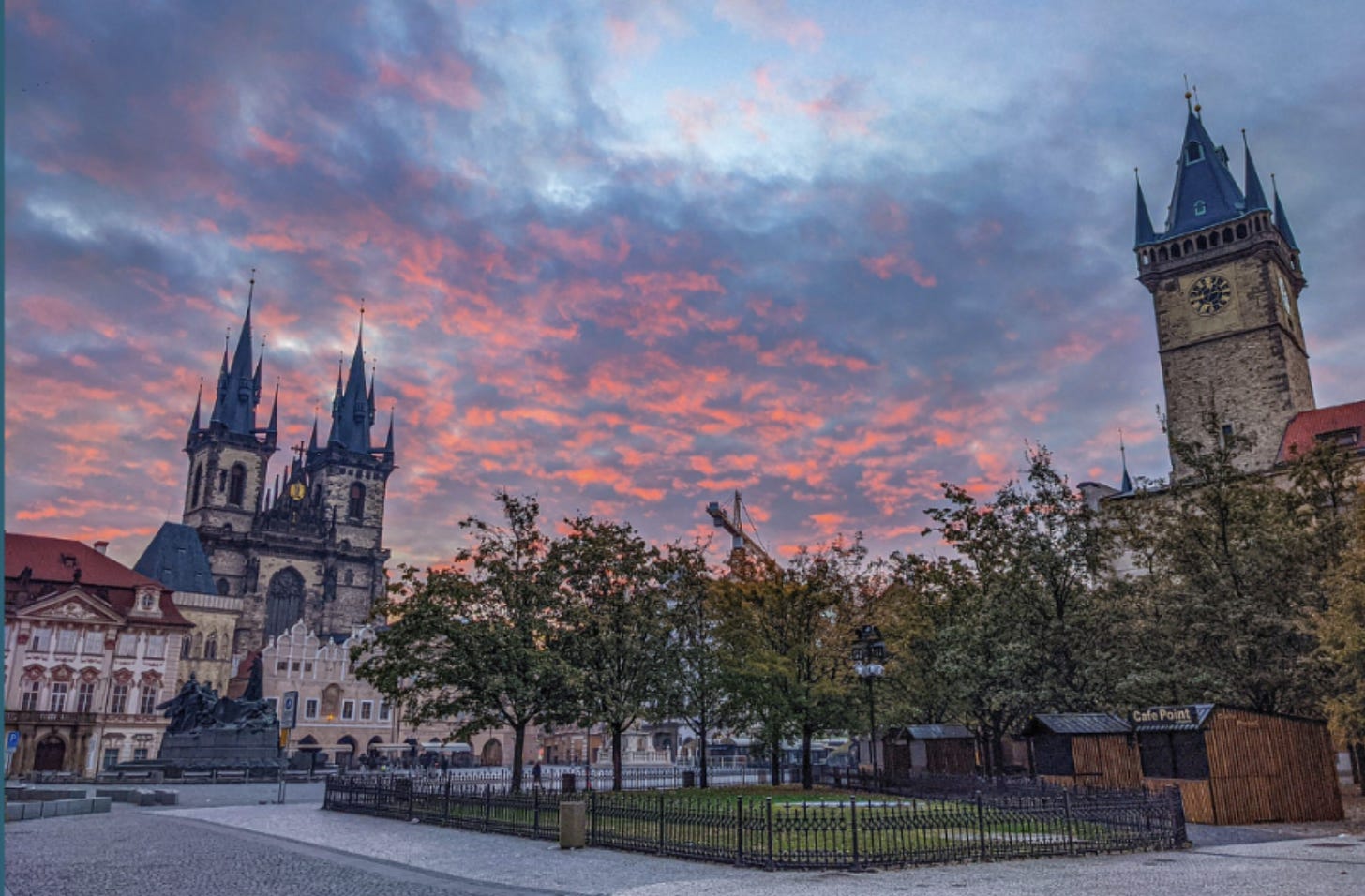 Pink and purple clouds frame the Church of Our Lady before Tyn and the Astronomical Clock Tower in Old Town Prague.