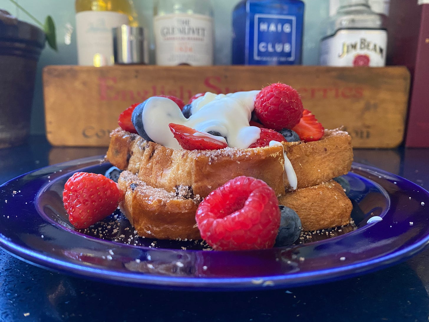 Blue plate with french toast, raspberries, blueberries and yoghurt