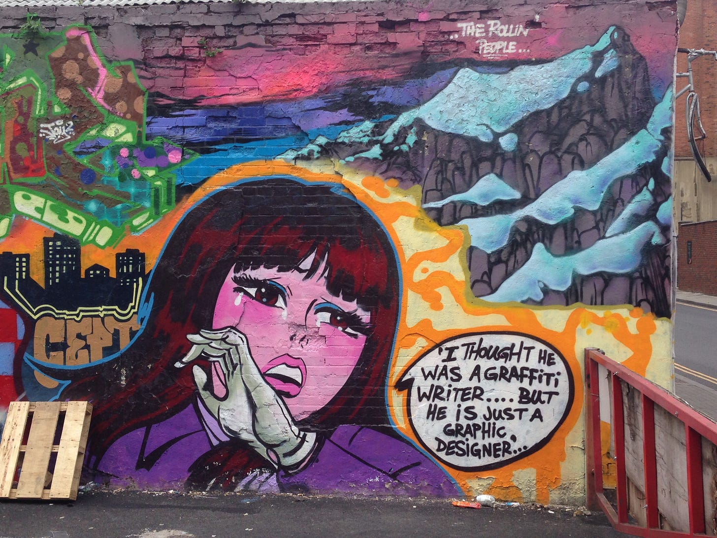 Photo of a wall covered in a graffiti mural showing a cartoon image of a girl with long dark hair and tears in her eyes with a speech bubble that reads 'I thought he was a graffiti writer... but he is just a graphic designer' art by Cept, photo taken by Sarah Farley