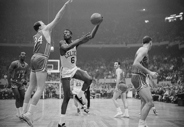 Boston Celtics' player Bill Russell hooks a shot during the NBA championship's final game in 1960 against the Saint Louis Hawks.